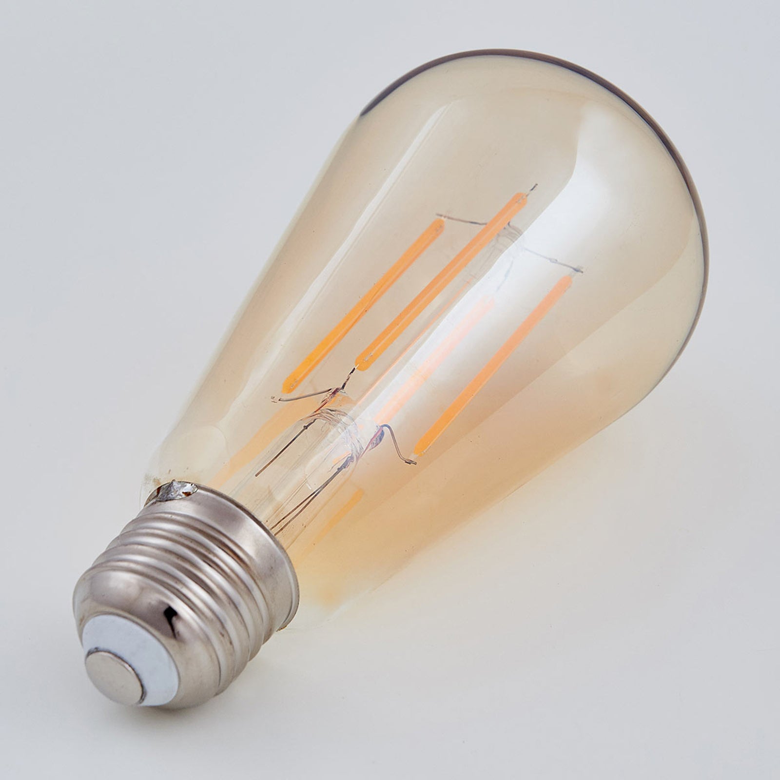 LED filamentpære E27 6W 1800K amber 3-pack nærbilde av glass