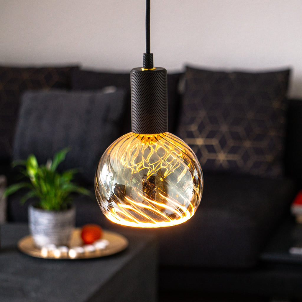Nærbilde av filament i LED filamentpære E27 6W 1900K globe G150 dimbar røykgrå