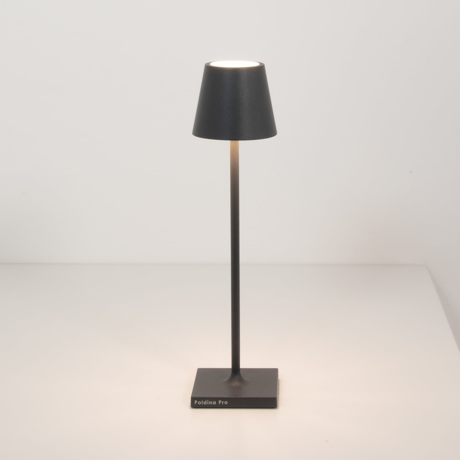 Nærbilde av LED oppladbar bordlampe Poldina micro mørkegrå IP65 på bord