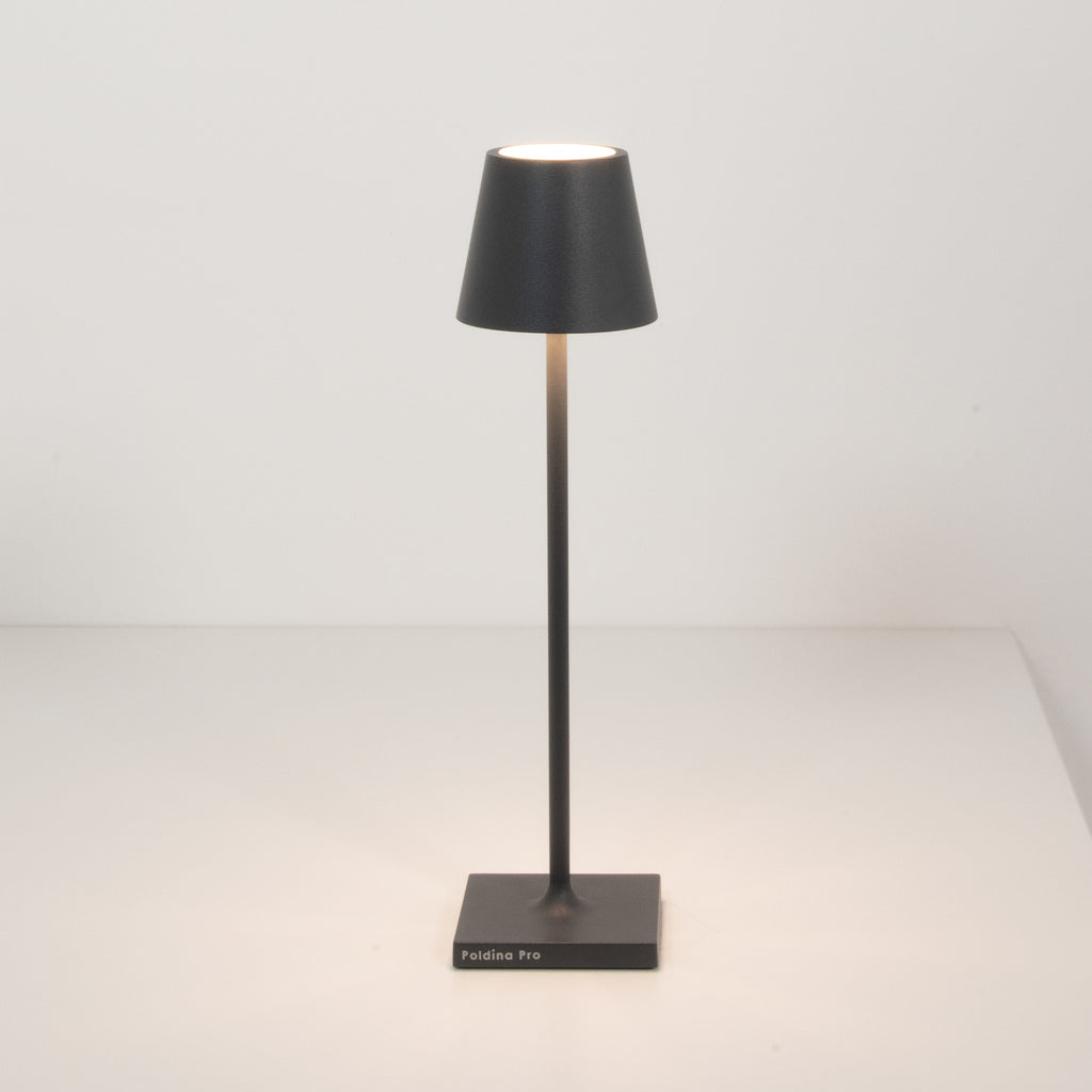 Nærbilde av LED oppladbar bordlampe Poldina micro mørkegrå IP65 på bord