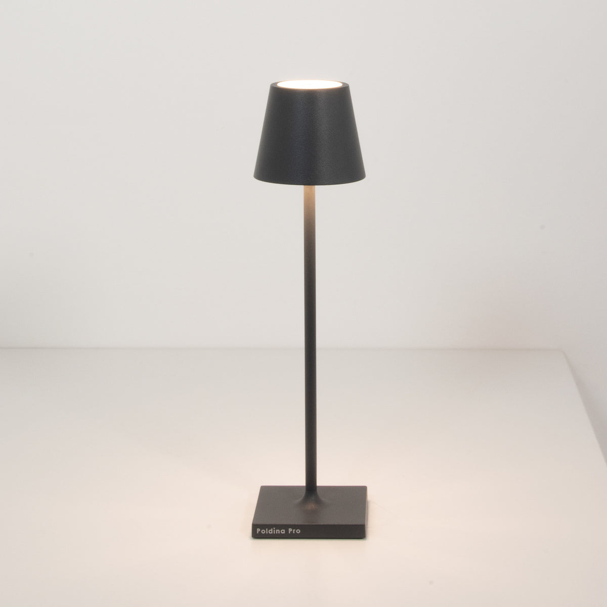 Nærbilde av LED oppladbar bordlampe Poldina micro mørkegrå IP65 på bord