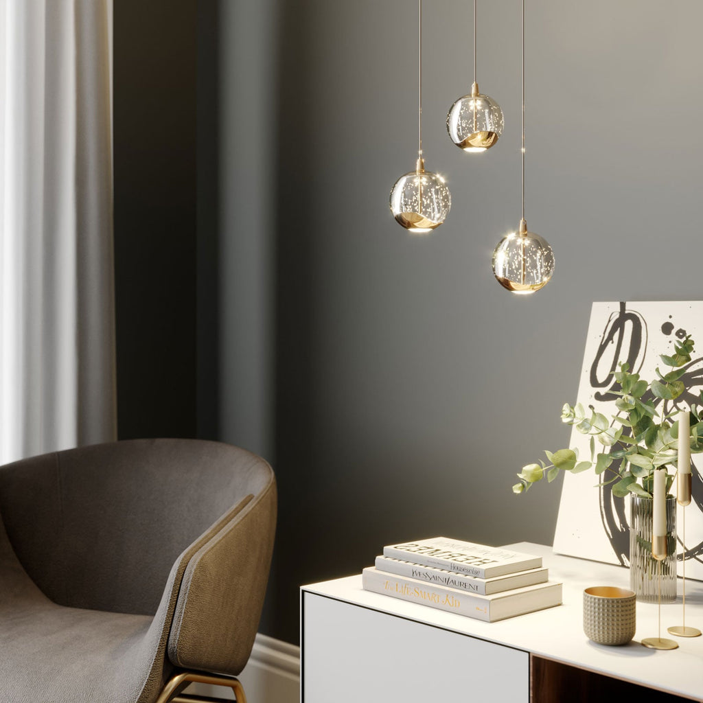 LED pendellampe Hayley 3-lys glass kuleform gull montert over bord