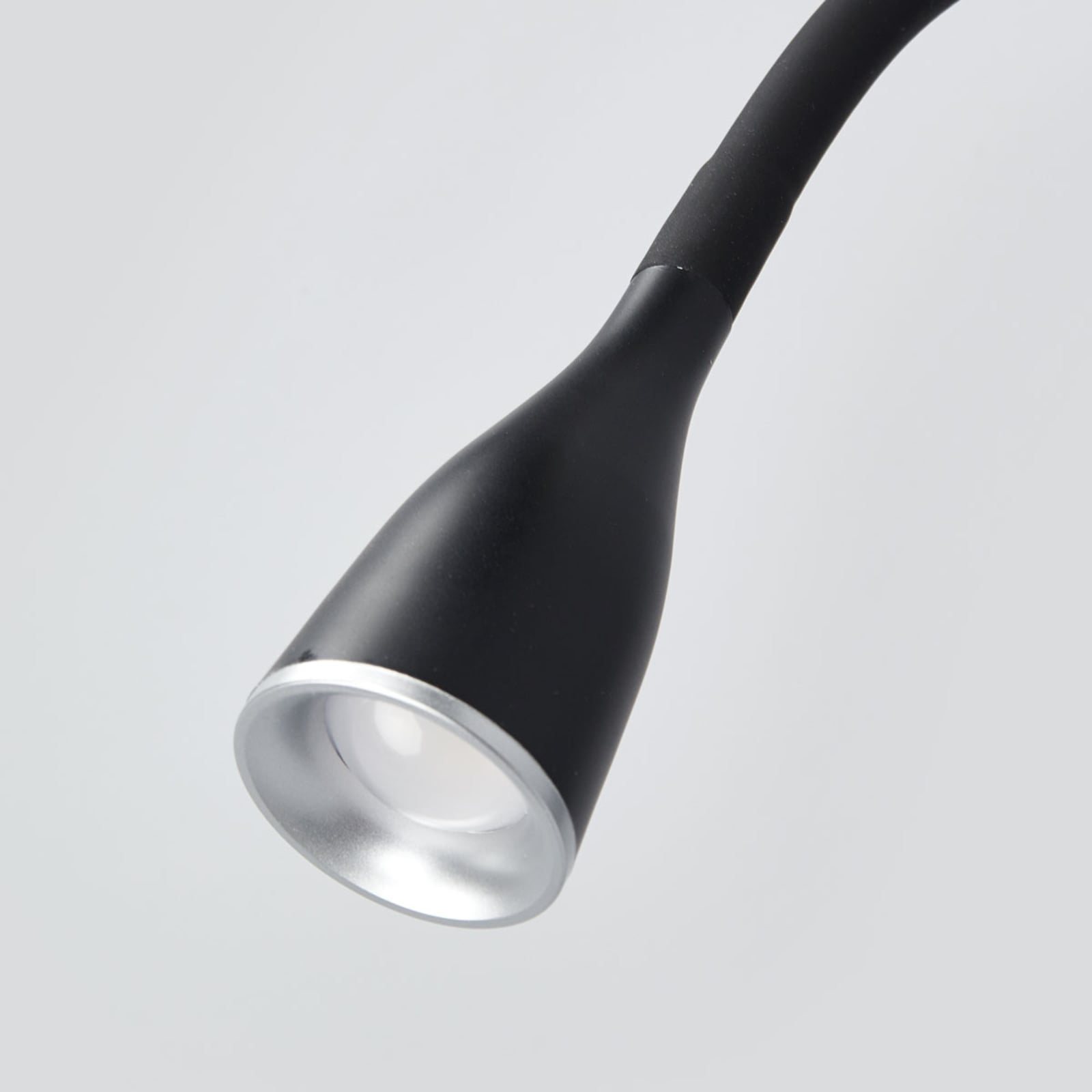 Nærbilde av fleksibel arm på LED vegglampe Enna svart med bryter og USB