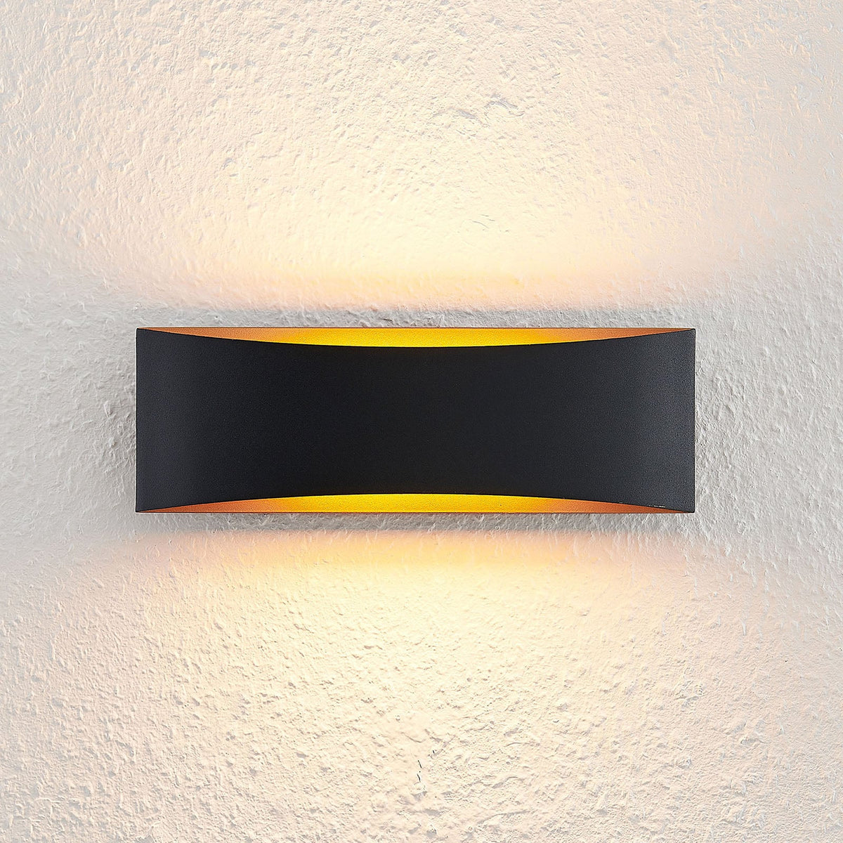 LED vegglampe Jelle opp og ned svart/gull montert i rom