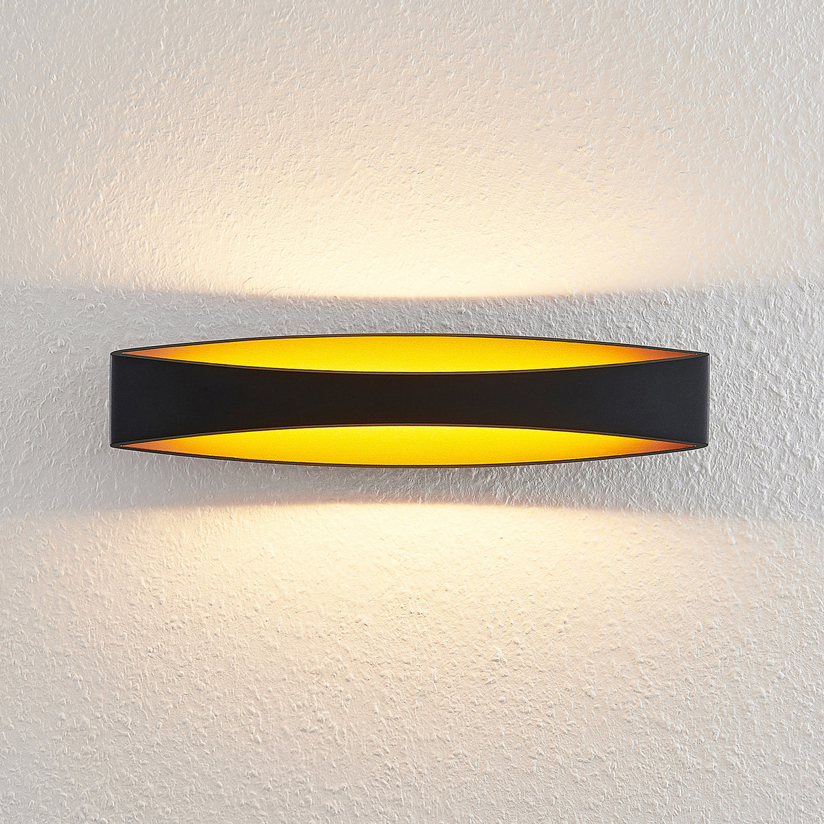 LED vegglampe Jelle opp og ned svart/gull montert i rom